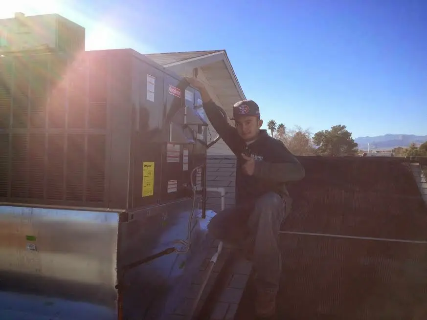 HVAC technician performing Air Duct Cleaning on a rooftop unit in Bellmead